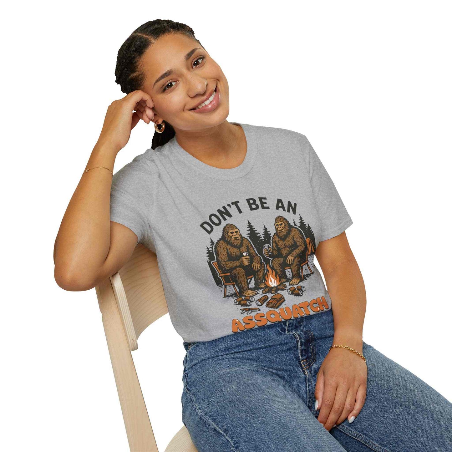 Woman wearing gray Funny Sasquatch Camping T-Shirt with Bigfoot sitting by campfire graphic